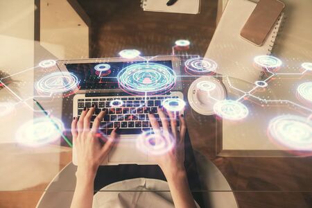 Double exposure of woman hands working on computer and social network theme hologram drawing. Top View. People connection concept.の写真素材
