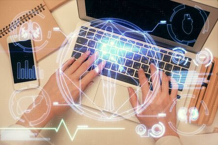 Double exposure of woman hands working on computer and education theme hologram drawing. Top View....