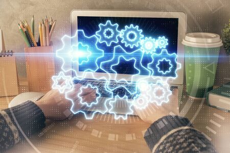 Double exposure of woman hands typing on computer and business theme hologram drawing. Success...