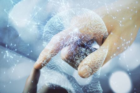 Double exposure of mans hand holding and using a digital device and brain hologram drawing. Data concept.の写真素材