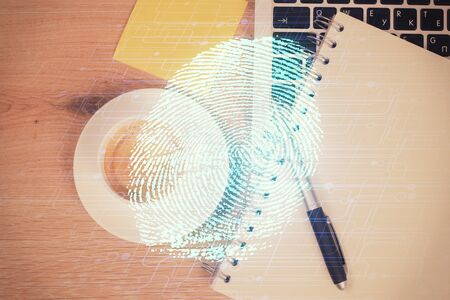 Finger print over computer on the desktop background. Top view. Double exposure. Concept of securitization.の写真素材