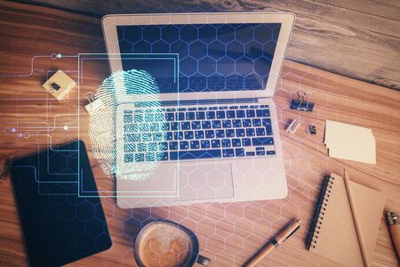 Finger print over computer on the desktop background. Top view. Double exposure. Concept of securitization.の写真素材