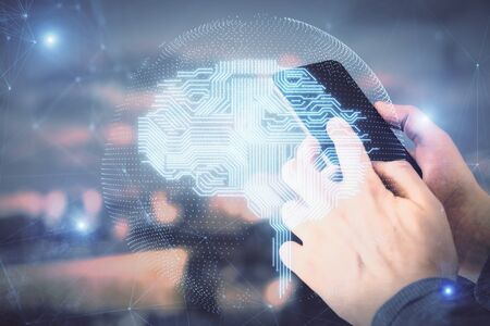 Double exposure of mans hand holding and using a digital device and brain hologram drawing. Data...