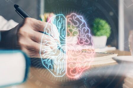 Multi exposure of writing hand on background with brain hologram. Concept of self learning.