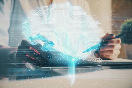 Multi exposure of writing hand on background with brain hologram. Concept of self learning.