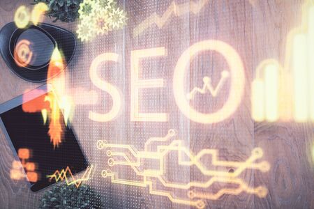 Double exposure of SEO hologram drawing over desktop. Top view. Search optimization concept.の写真素材