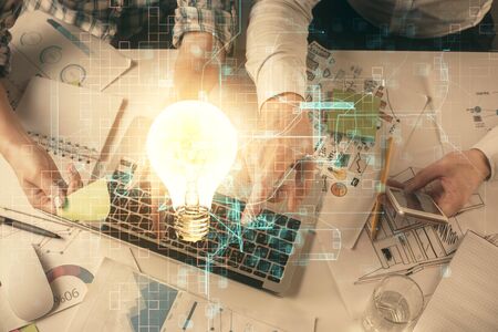 Double exposure of man and woman working together and bulb drawing. Computer background. Top View. Idea concept.の写真素材