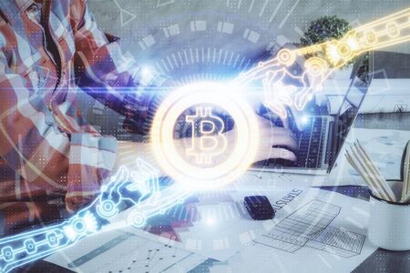 Crypto currency theme hologram with businessman working on computer on background. Concept of blockchain. Multi exposure.の写真素材