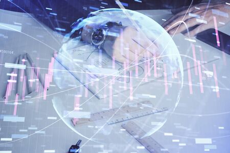 Double exposure of mans hands writing notes of stock market with forex graph background. Concept of research and trading.の写真素材