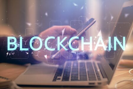 Double exposure of mans hands holding and using a phone and crypto currency blockchain theme...