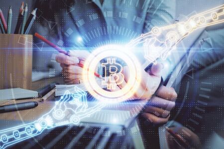 Cryptocurrency hologram over womans hands writing background. Concept of blockchain. Multi exposureの写真素材