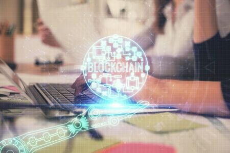 Double exposure of woman hands typing on computer and crypto market theme hologram drawing. Blockchain concept.の写真素材