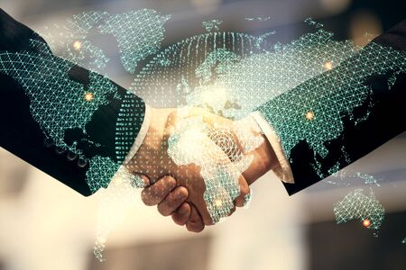 Double exposure of business theme hologram and handshake of two men. Success concept.の写真素材