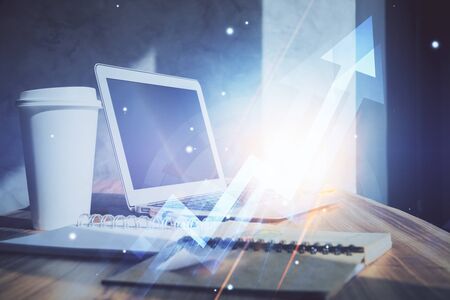 Computer on desktop with point up arrows hologram. Double exposure. Concept of success.の写真素材