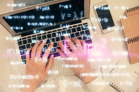 Double exposure of woman hands working on computer and formula hologram drawing. Top View. Science concept.の写真素材