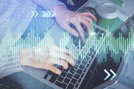Double exposure of woman hands typing on computer and forex chart hologram drawing. Stock market invest concept.の写真素材