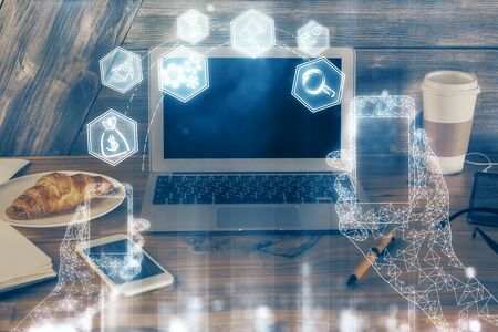 Computer on desktop in office with technology theme hologram. Multi exposure. Tech concept.の写真素材