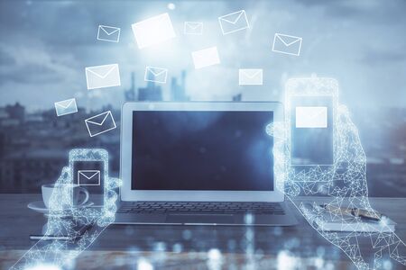 Desktop computer background in office and flying envelops hologram drawing. Multi exposure. Electronic mail concept.の写真素材