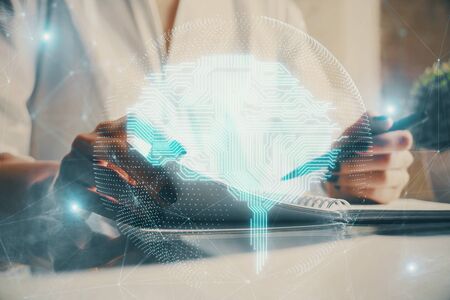 Multi exposure of writing hand on background with brain hologram. Concept of self learning.