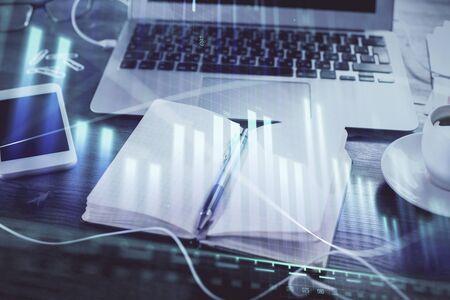 Multi exposure of financial graph drawings and desk with open notebook background. Concept of forexの写真素材