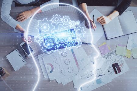 Double exposure of woman working on computer andhuman brain hologram drawing. Top View. Ai concept.