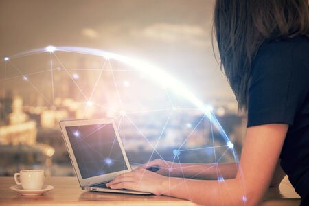 Double exposure of woman hands typing on computer and social network theme hologram drawing. People media concept.の写真素材