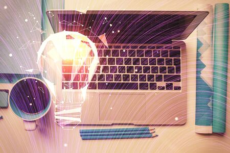 Bulb drawing over computer on the desktop background. Top view. Double exposure. Idea concept.の写真素材