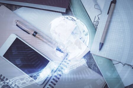 Double exposure of map hologram drawing over desktop. Top view. International connection concept.の写真素材