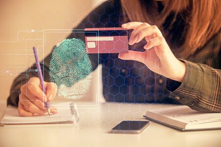 Multi exposure of woman on-line shopping holding a credit card and finger print drawing. Security concept.の写真素材
