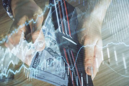Multi exposure of forex graph drawing hologram and USA dollars bills and man hands. Technical...