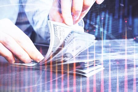 Multi exposure of forex graph drawing hologram and USA dollars bills and man hands. Technical...