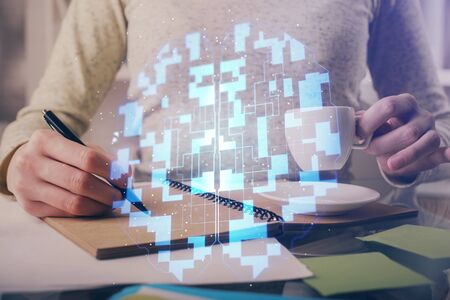 Double exposure of writing hands on background with data solution hologram on front. Technology concept. Side view.の写真素材
