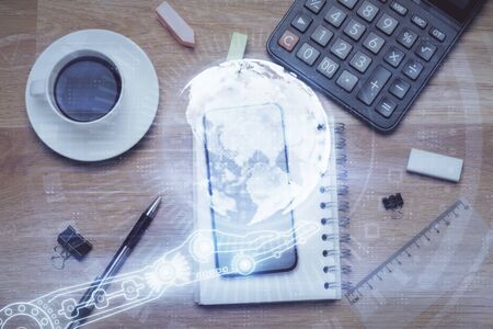 Double exposure of map hologram drawing over desktop. Top view. International connection concept.の写真素材
