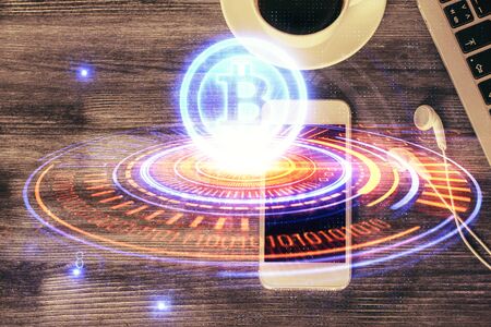 Double exposure of blockchain theme hologram over table with phone. Top view. Crypto technology concept.の写真素材