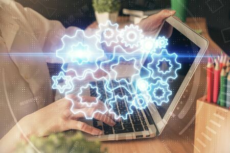 Double exposure of woman hands typing on computer and business theme hologram drawing. Success...