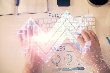 Double exposure of mans hands typing over computer keyboard and growing arrows hologram drawing. Top view. Success concept.の写真素材