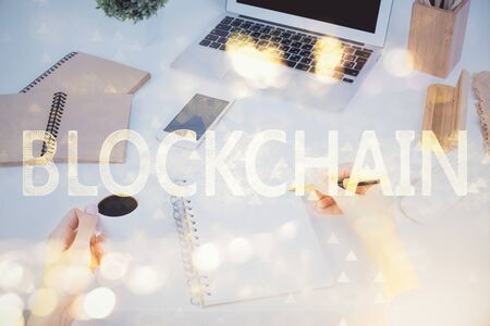 Cryptocurrency hologram over womans hands writing background. Concept of blockchain. Multi exposureの写真素材