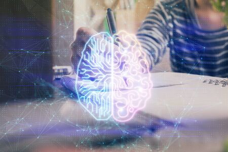 Multi exposure of writing hand on background with brain hologram. Concept of self learning.