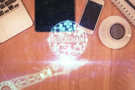 Double exposure of blockchain theme hologram over table with phone. Top view. Crypto technology concept.の写真素材