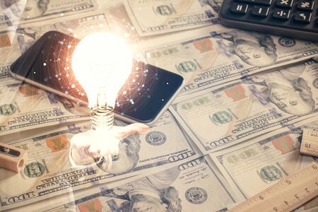 Double exposure of light bulb drawing over usa dollars bill background. Concept of idea.の写真素材