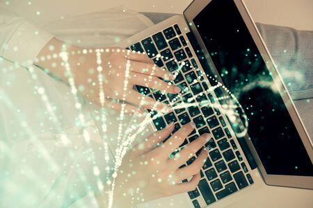 Double exposure of woman hands working on computer and DNA hologram drawing. Top View. Medical education concept.の写真素材
