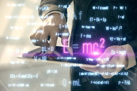 Double exposure of mans hands holding and using a phone and formulas drawing. Education concept.の写真素材