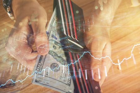 Multi exposure of forex graph drawing hologram and USA dollars bills and man hands. Technical...