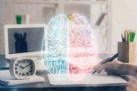 Multi exposure of writing hand on background with brain hologram. Concept of learning.の写真素材