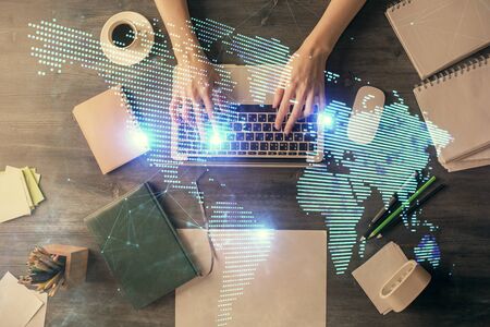 Double exposure of woman hands working on computer and social network theme hologram drawing. Top View. People connection concept.の写真素材