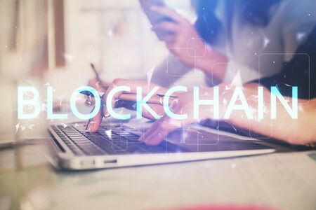 Double exposure of woman hands typing on computer and crypto market theme hologram drawing. Blockchain concept.の写真素材