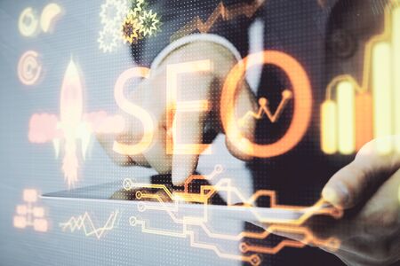 Multi exposure of mans hands holding and using a digital device and seo drawing. search optimization concept.の写真素材