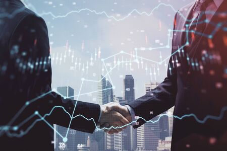 Double exposure of forex graph hologram and handshake of two men. Stock market concept.の写真素材