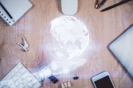 Double exposure of map hologram drawing over desktop. Top view. International connection concept.の写真素材