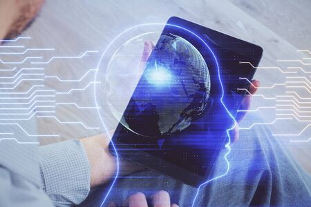 Double exposure of mans hand holding and using a digital device and brain hologram drawing. Data concept.の写真素材